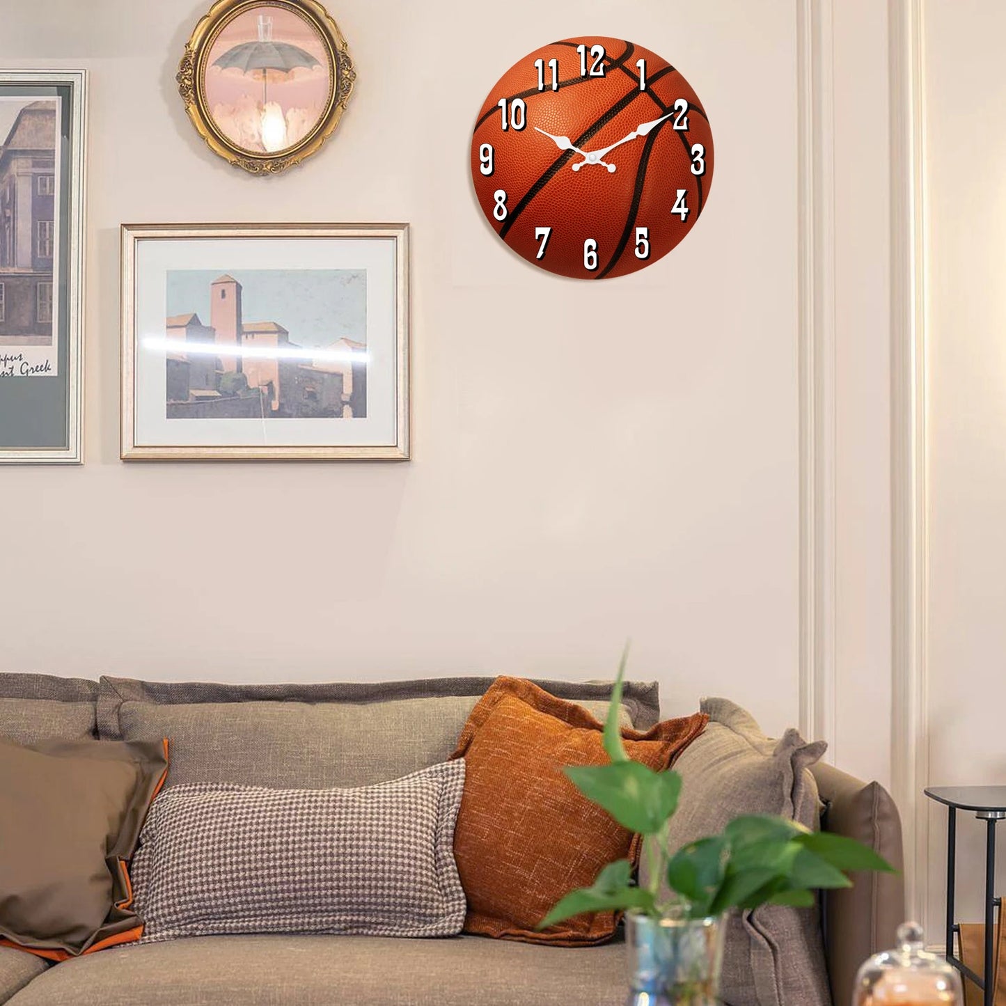 Basketball wall clock displayed above a living room sofa, featuring a realistic basketball design and silent quartz movement for stylish sports-themed home, office, or game room decor.
