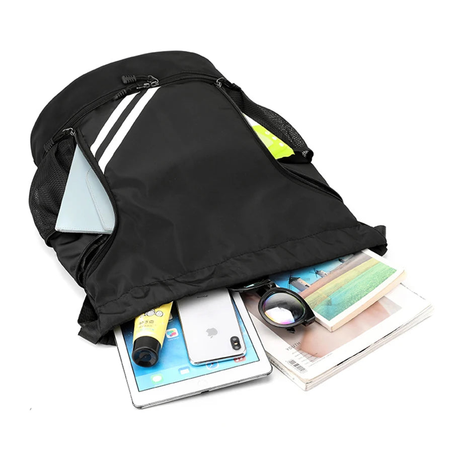 Black backpack with items like a phone, tablet, and books spilling out on a white background